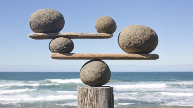 rocks-balancing-on-driftwood--sea-in-background-153081592-591bbc3f5f9b58f4c0b7bb16