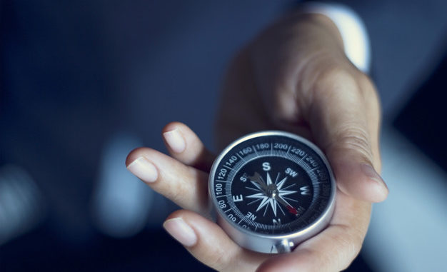 Businessman with a compass holding in hand, color tone film look